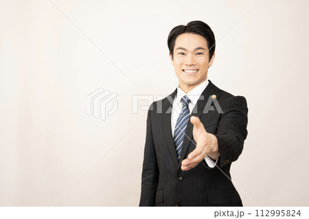 白バックで左手を差し出して微笑む弁護士 112995824