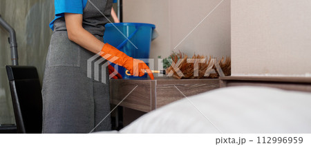 Cleaning service woman worker cleaning in bedroom at apartment. housekeeper cleaner feel happy and use feather duster wiping messy dirty for housekeeping housework or chores Cleaning service woman worker cleaning in bedroom at apartment. housekeeper cleaner feel happy and use feather duster wiping messy dirty for housekeeping housework or chores 112996959
