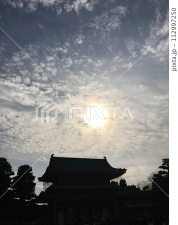 お寺の屋根と夕焼け 112997250