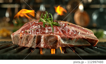 Close-up of tasty raw beef steak on cast-iron grate with fire flames Close-up of tasty raw beef steak on cast-iron grate with fire flames 112997480