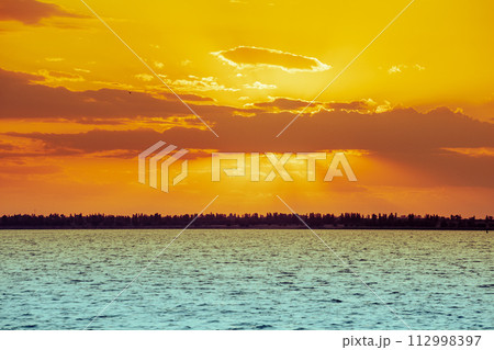 Seascape in the evening. Golden sunset over the sea with beautiful sky Seascape in the evening. Golden sunset over the sea with beautiful sky 112998397