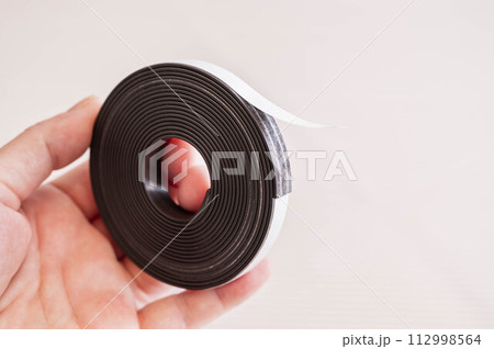 手に持つマグネットテープ 手に持つマグネットテープ 112998564