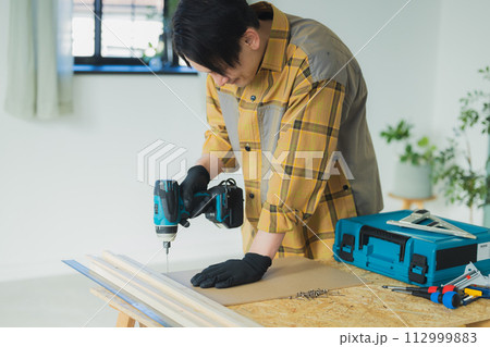 電動ドライバーで作業する若い男性 電動ドライバーで作業する若い男性 112999883