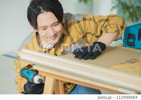 電動ドライバーで作業する若い男性 電動ドライバーで作業する若い男性 112999884