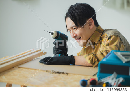 電動ドライバーで作業する若い男性　　 112999888