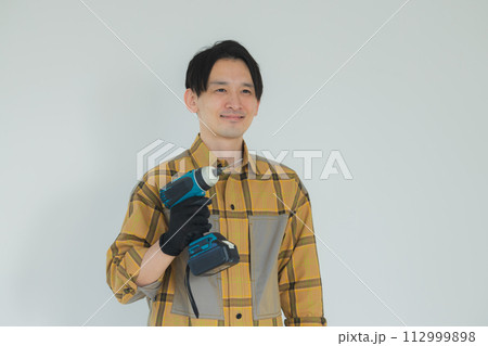 電動ドライバーで作業する若い男性 電動ドライバーで作業する若い男性 112999898