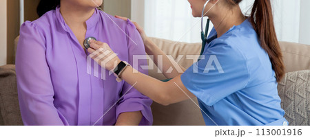 Young asian nurse or caregiver sitting on sofa holding stethoscope listen heartbeat with senior. Young asian nurse or caregiver sitting on sofa holding stethoscope listen heartbeat with senior. 113001916