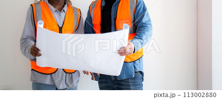 Team of architect or engineer wearing hardhat looking blueprint for inspection and planning. 113002880