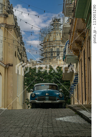 An old retro car on a narrow street in Havana against the backdrop of a colonial cathedral. 113003290