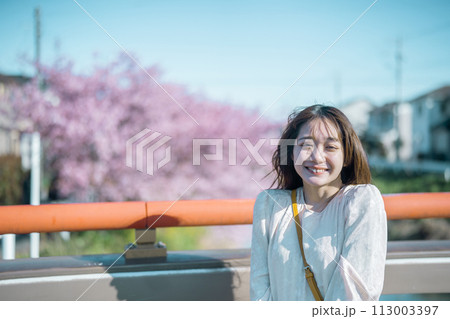 河津桜と笑顔の女性 113003397