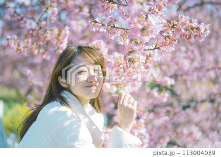 桜の下でお団子を食べる女性 113004089