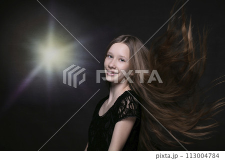 Portrait of a beautiful teenage girl with fluttering strands of hair. 113004784