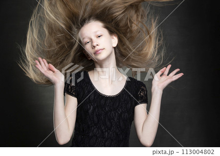 Beautiful teenager girl with flowing hair on a gray background. Beautiful teenager girl with flowing hair on a gray background. 113004802