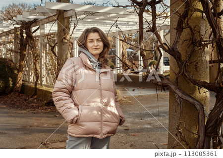 Young beautiful pretty tourist girl in warm hat and coat with backpack walking at cold autumn in Europe city enjoying her travel in Bietigheim-Bissingen, Deutschland. Outdoor portrait of young tourist 113005361
