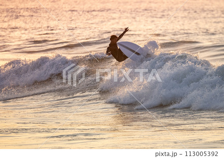 Sporty boy riding his surf board 113005392