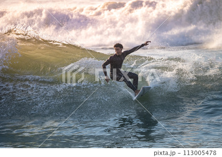 Sporty boy riding his surf board 113005478