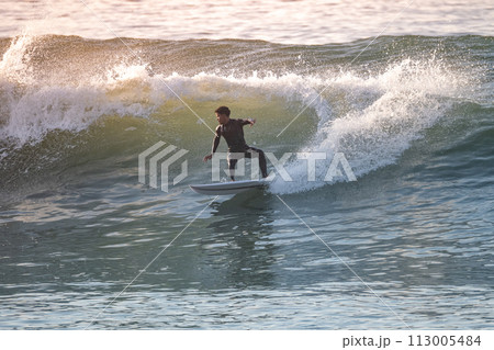 Young surfer enjoying waves Young surfer enjoying waves 113005484