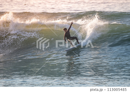 Brave teenager making tricks on the rough sea 113005485