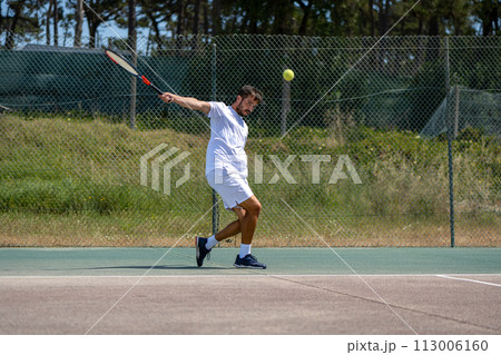 Tennis player hitting backhand at ball Tennis player hitting backhand at ball 113006160