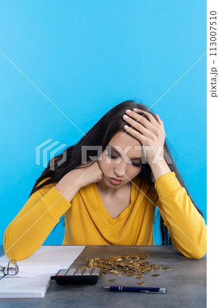 A poor young girl counts money at home at her desk, hoping that she will have enough for all expenses. A poor young girl counts money at home at her desk, hoping that she will have enough for all expenses. 113007510
