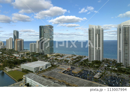 View from above of luxurious highrise hotels and condos on Atlantic ocean shore in Sunny Isles Beach city. American tourism infrastructure in southern Florida 113007994