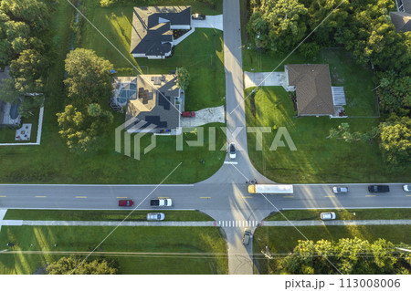 Top view of standard american yellow school bus picking up kids at rural town street stop for their lessongs in early morning. Public transport in the USA Top view of standard american yellow school bus picking up kids at rural town street stop for their lessongs in early morning. Public transport in the USA 113008006