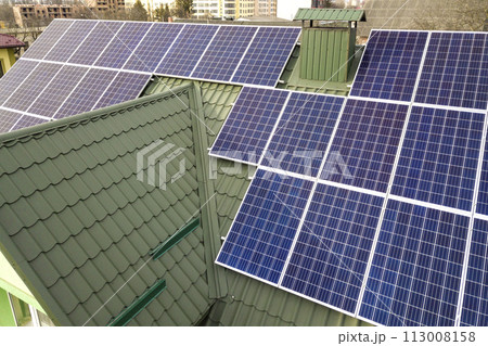 Close-up surface of blue shiny solar photo voltaic panels system on building roof. Renewable ecological green energy production concept. Close-up surface of blue shiny solar photo voltaic panels system on building roof. Renewable ecological green energy production concept. 113008158