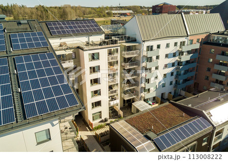 Aerial view of solar photovoltaic panels on a roof top of residential building block for producing clean electric energy. Autonomous housing concept. 113008222