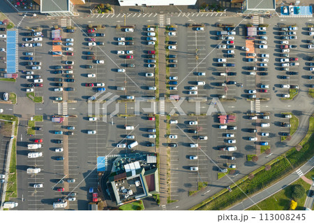 Aerial view of many colorful cars parked on parking lot with lines and markings for parking places and directions Aerial view of many colorful cars parked on parking lot with lines and markings for parking places and directions 113008245