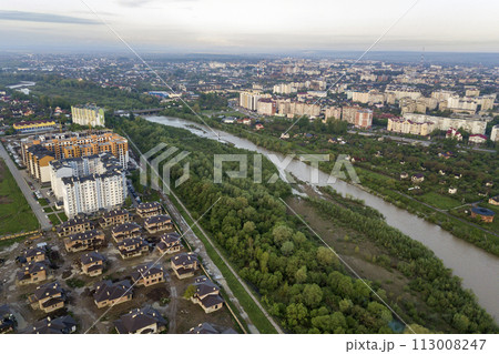 Aerial view of Ivano-Frankivsk city with residential area and suburb houses with a river in middle. Aerial view of Ivano-Frankivsk city with residential area and suburb houses with a river in middle. 113008247