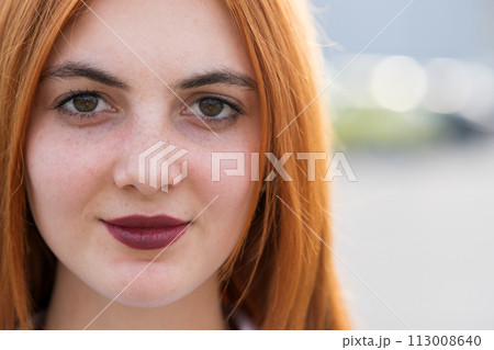 Closeup face portrait of a girl with red hair and clear eyes. 113008640