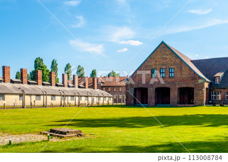The infamous Auschwitz concentration camp with its characteristic brick buildings and fences under a clear sky, now a site of remembrance. Oswiecim, Poland The infamous Auschwitz concentration camp with its characteristic brick buildings and fences under a clear sky, now a site of remembrance. Oswiecim, Poland 113008784