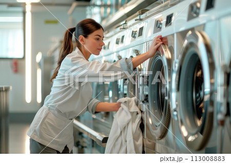 Numerous washing machines lined up in a spacious room, ready for use. The industrial appliances for laundry purposes Numerous washing machines lined up in a spacious room, ready for use. The industrial appliances for laundry purposes 113008883
