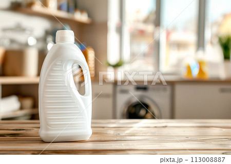 Plain detergent bottle on wood over defocused laundry room interior 113008887