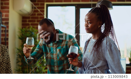 School colleagues organizing reunion party at home, enthusiastically dancing to disco music. Friends celebrating many years of friendship, enjoying, busting into skillful dance moves at social event 113009843