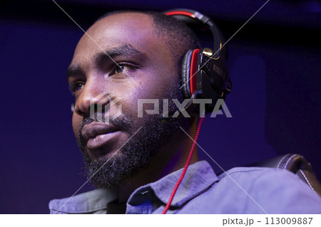 Close up of pro man streaming videogame on powerful computer during online gaming championship, talking into headset. Gamer taking part in Esport team of gamers, competing in game 113009887
