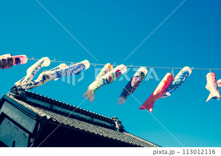 蔵の屋根の上に並んで泳ぐ鯉のぼりと青空　暖色加味 113012116