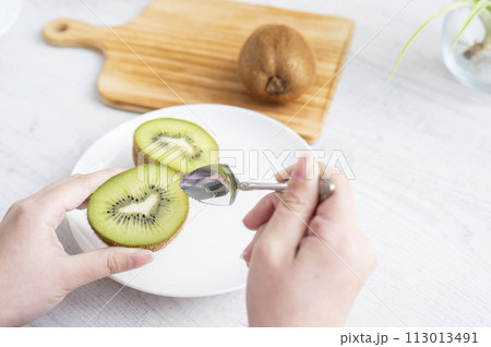 キウイフルーツを食べる女性の手 113013491