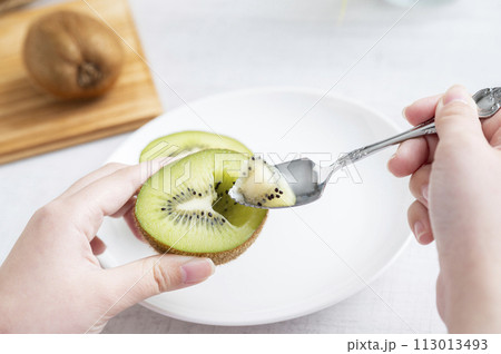 キウイフルーツを食べる女性の手 113013493