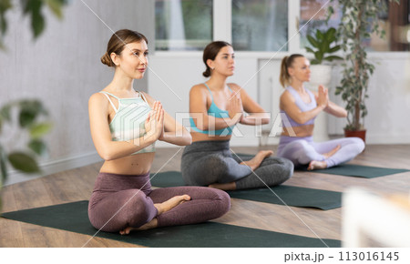 Young woman practicing lotus pose in yoga studio Young woman practicing lotus pose in yoga studio 113016145