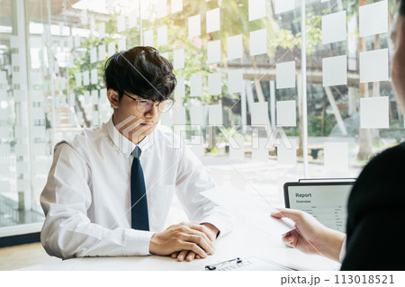 Male manager is talking or explaining about having to dismiss the employee while being handed out a resignation envelope to the employee. Male manager is talking or explaining about having to dismiss the employee while being handed out a resignation envelope to the employee. 113018521