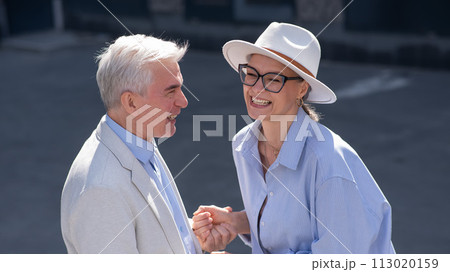 Stylish elderly laughing couple on a walk. Romantic relationships of mature people.  113020159