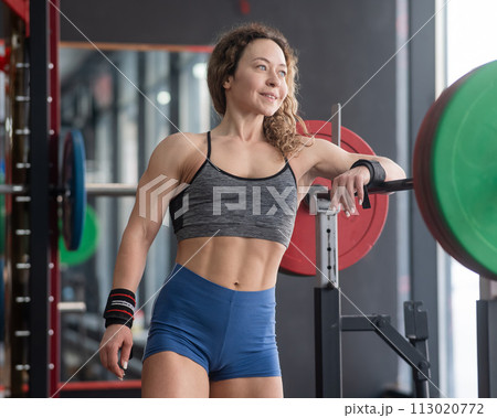 Middle aged woman resting before deadlifting at the gym.  113020772