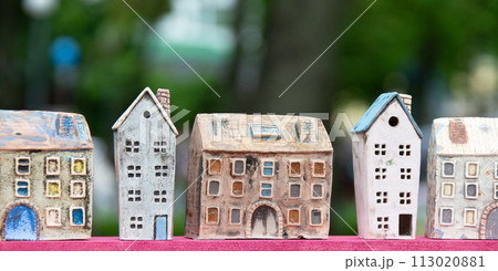 Small toy houses on a background of greenery. Toy street. Small toy houses on a background of greenery. Toy street. 113020881
