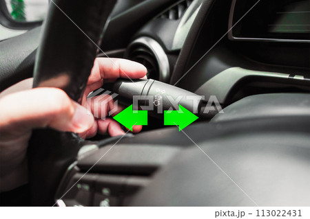 Driver hand using turn signal in a car 113022431
