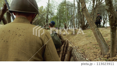 Reconstruction Of Battles World War Ii. Re-enactors Dressed As Soviet Russian Soldiers Take Up Fighting Positions In Trenches. Position Defense. Soldiers Aiming With Rifles 113023911