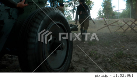 Group Of Re-enactors Dressed As Russian Soviet Red Army Infantry Soldiers Of World War Ii Are Move Soviet 45mm Anti-tank Gun To Combat Position. Preparing For Historical Reenactment 113023961