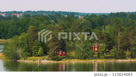 Panoramic View On Many Red Swedish Wooden Sauna Logs Cabins Houses On Island Coast In Summer Cloudy Day. Swedish Old Tradition Wooden Houses. Bold Colors. Travel to Sweden Panoramic View On Many Red Swedish Wooden Sauna Logs Cabins Houses On Island Coast In Summer Cloudy Day. Swedish Old Tradition Wooden Houses. Bold Colors. Travel to Sweden 113024063
