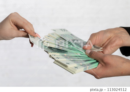 A woman's hand draws a banknote that may bring her luck in the future. A woman's hand draws a banknote that may bring her luck in the future. 113024512