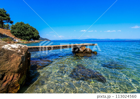 Beautiful scene from wooden pier and turquoise sea.Tarsanas Beach, Thassos, Greece Beautiful scene from wooden pier and turquoise sea.Tarsanas Beach, Thassos, Greece 113024560